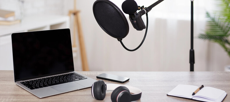 Podcaster revisando la escaleta y las notas del episodio junto a un micrófono de estudio